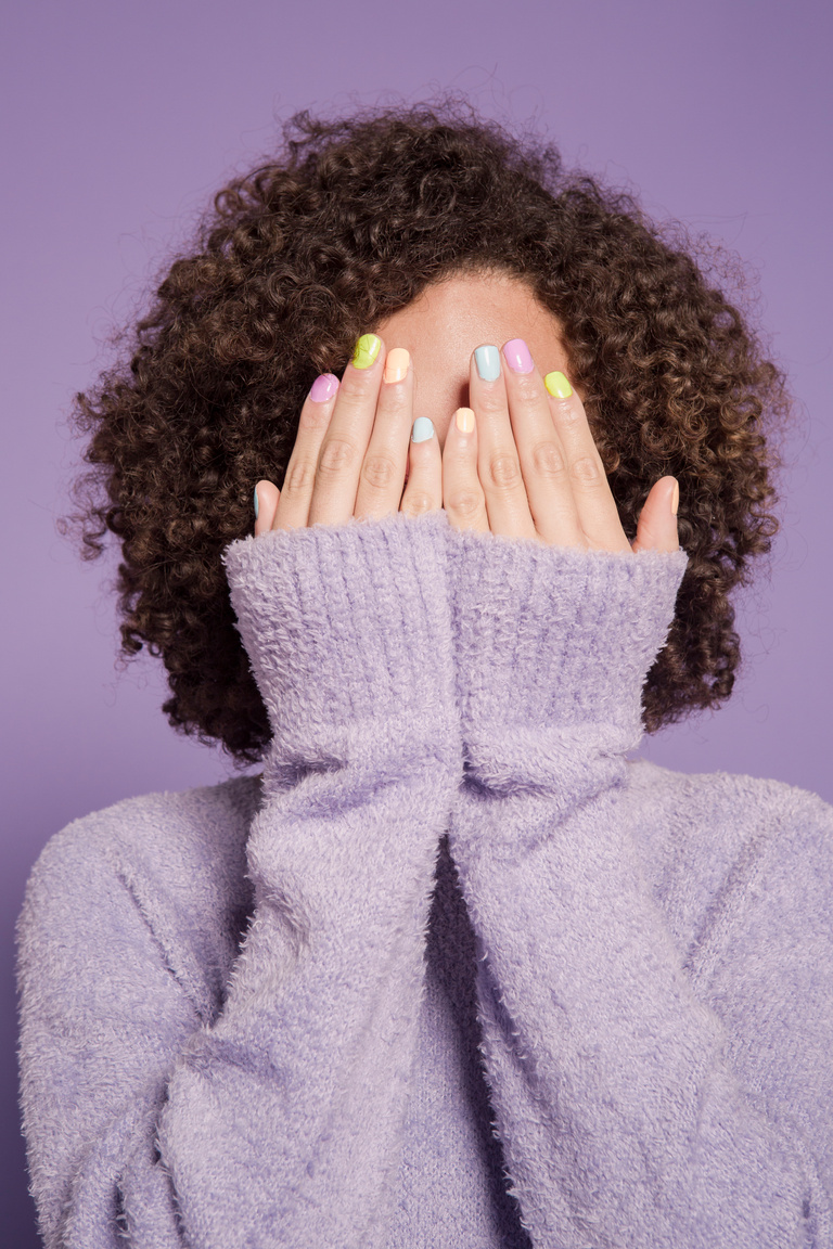 Shy woman covering face with hands